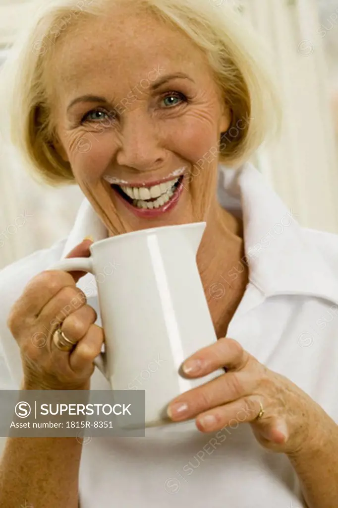 Senior woman drinking milk, close-up, portrait