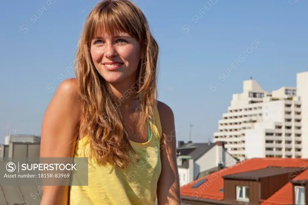 Germany, Bavaria, Munich, Young woman looking away, smiling