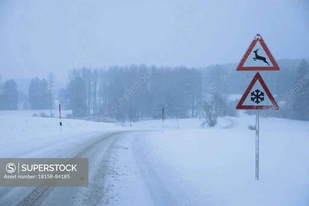 Germany, Bavaria, Moerlbach, View of country road covered in snow with sign board