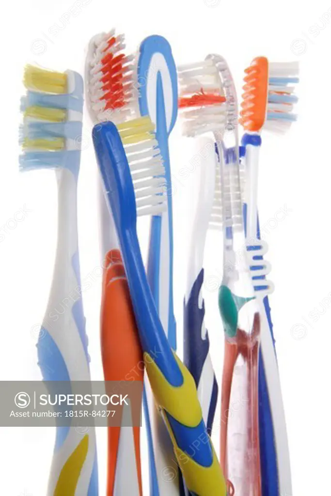 Variety of used toothbrush against white background, close up