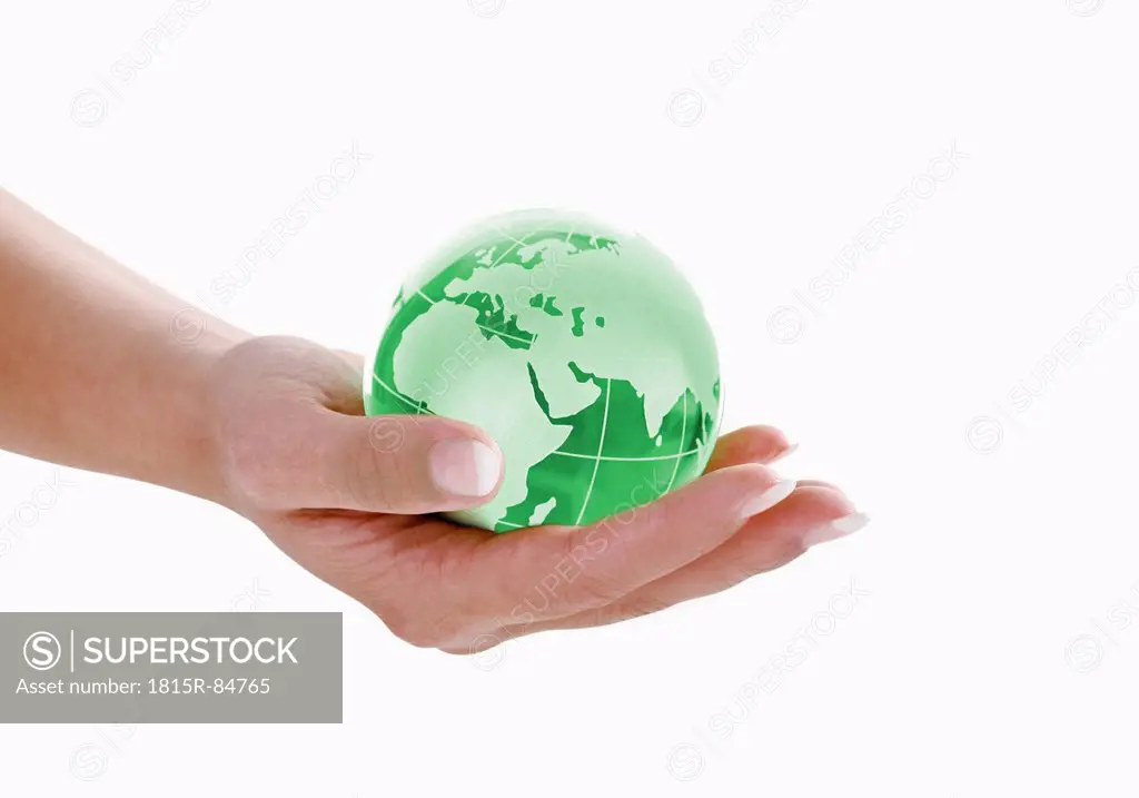 Green Globe in woman hand against white background