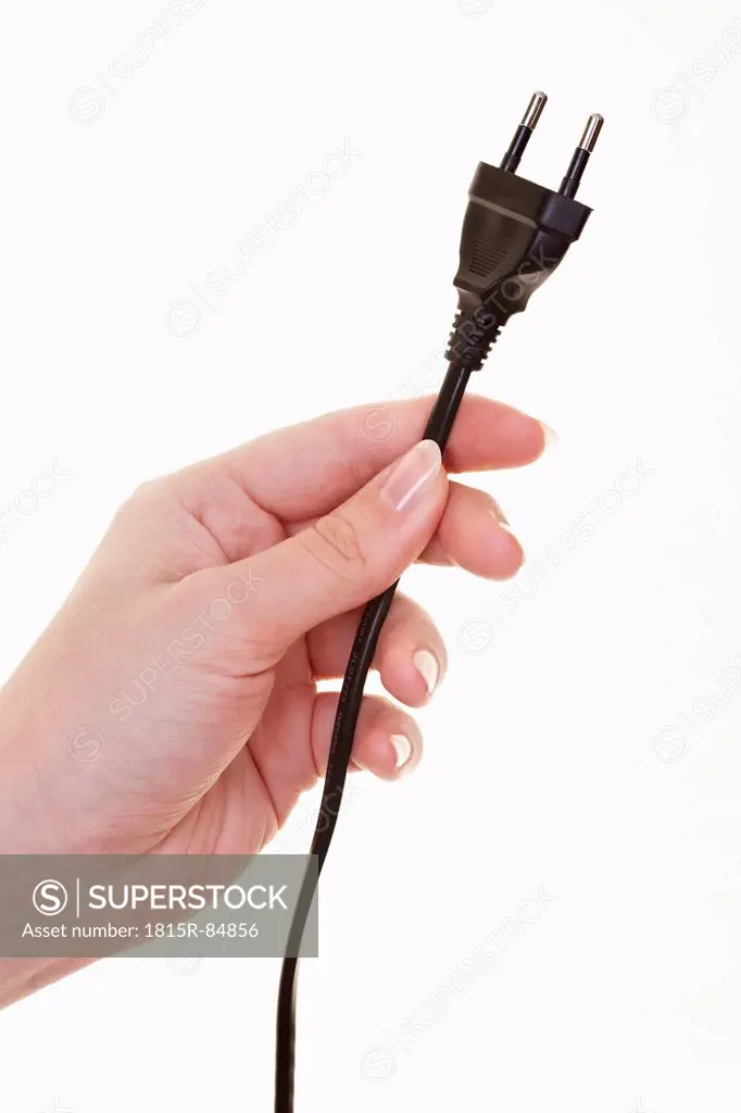 Hand of woman holding power cable against white background, close up
