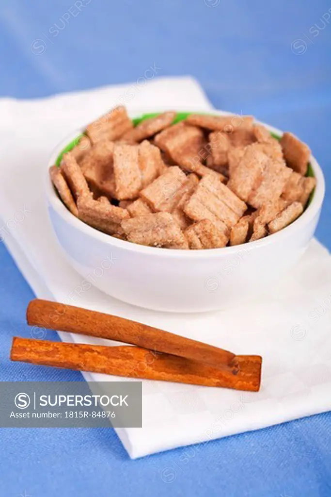 Close up of cinnamon cereal chips in bowl with cinnamon stick