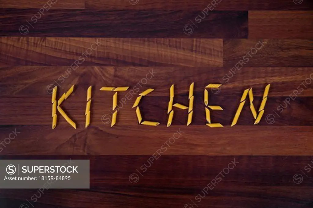 Close up of word kitchen written with penne on wooden background