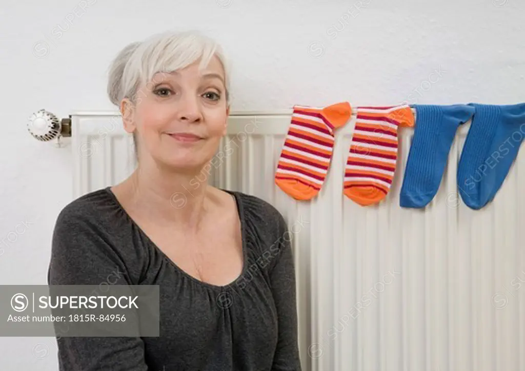 Germany, Duesseldorf, Woman near heater with socks on it