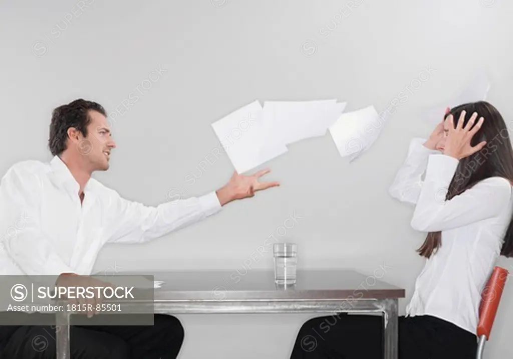 Business man throwing papers with woman head in hand