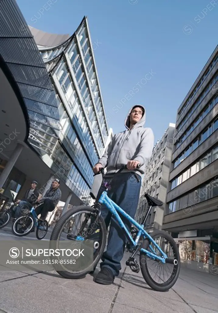 Germany, Stuttgart, Young men with BMX bike in city