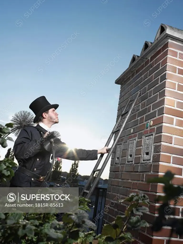 Germany, Chimney sweep with broom climbing ladder