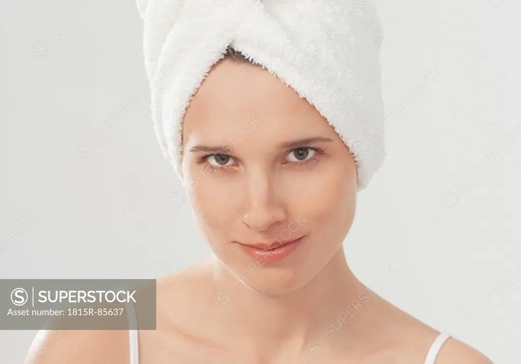 Young woman with towel wrapped around hair, portrait