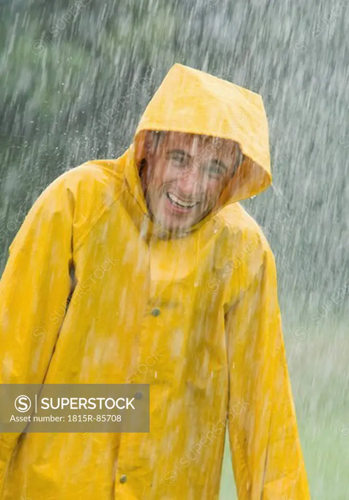 Man wearing rain coat standing in rain, portrait