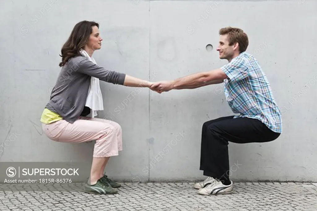 Germany, Berlin, Man and woman playing against wall