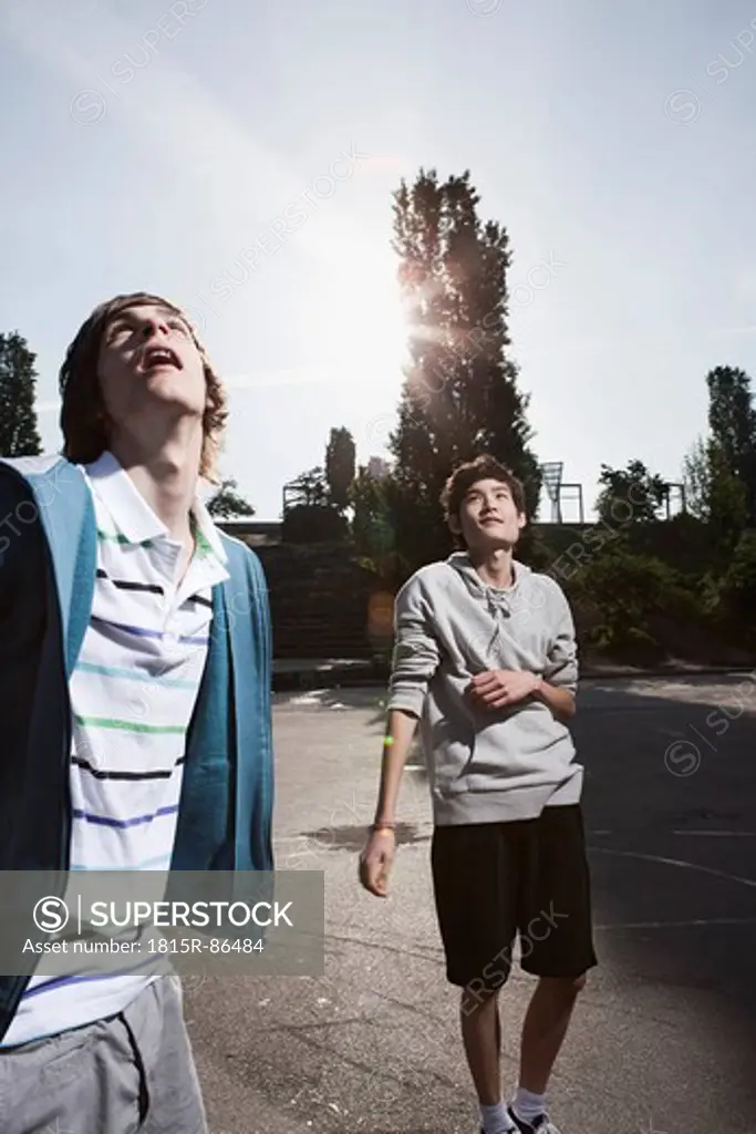 Germany, Berlin, Teenage boys standing in playground, looking up