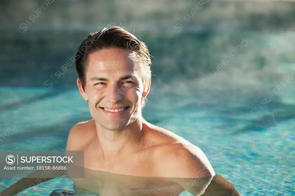 Italy, South Tyrol, Man in swimming pool of hotel urthaler, smiling