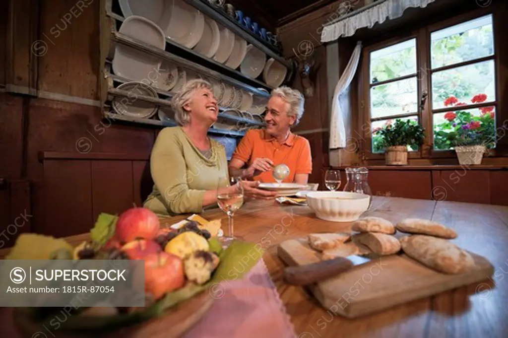 Italy, South Tyrol, Mature couple having their snacks at guesthouse