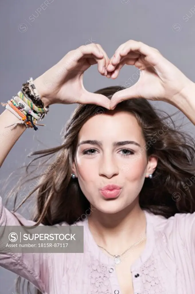 Girl makes a heart with her hands, portrait