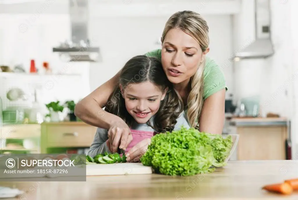 Germany, Cologne, Mother and daughter preparing salad