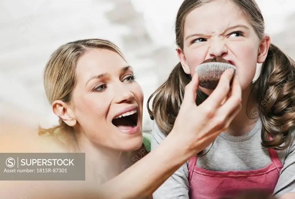 Germany, Cologne, Mother feeding cup cake to daughter