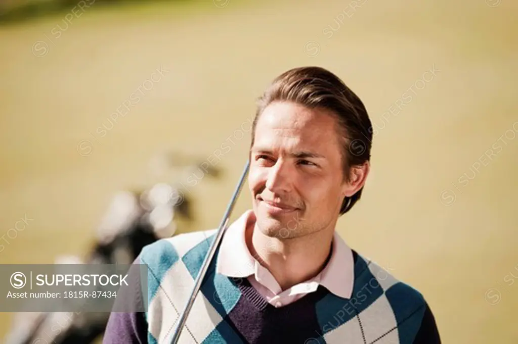 Italy, Kastelruth, Mid adult man with golf bag on golf course