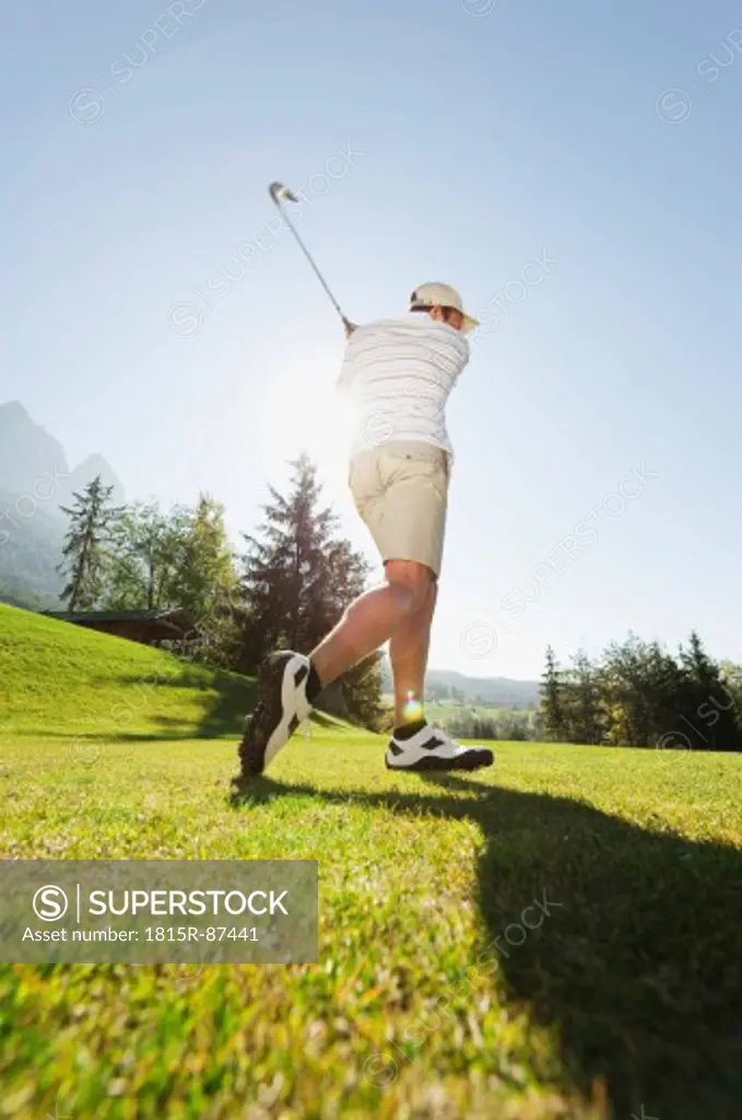 Italy, Kastelruth, Mid adult man playing golf on golf course