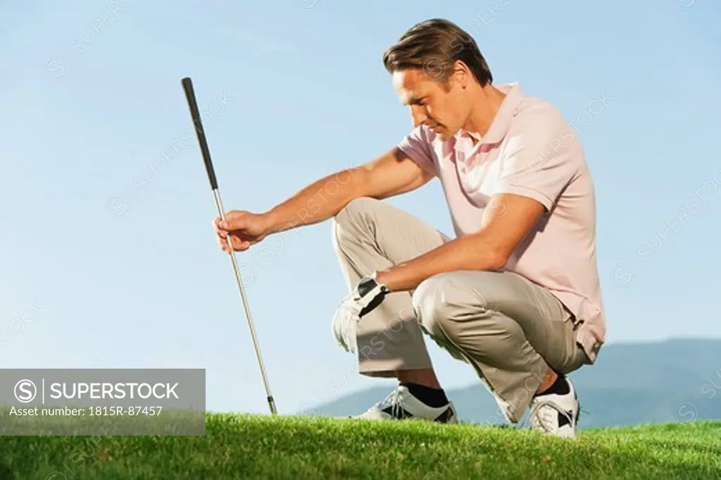 Italy, Kastelruth, Mid adult man with golf club on golf course