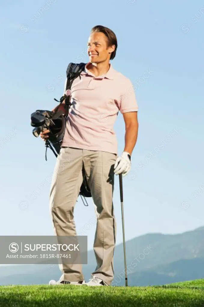 Italy, Kastelruth, Mid adult man with golf bag on golf course
