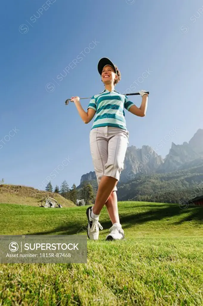 Italy, Kastelruth, Mid adult woman with golf club on golf course