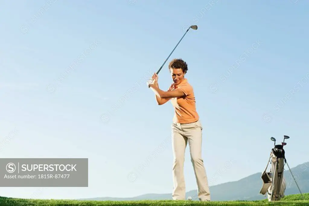 Italy, Kastelruth, Mid adult woman playing golf on golf course