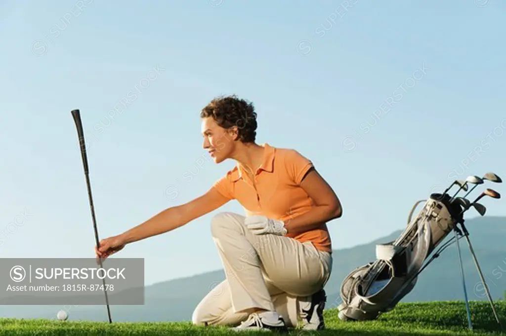 Italy, Kastelruth, Mid adult woman holding golf club on golf course