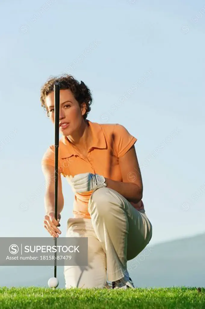 Italy, Kastelruth, Mid adult woman holding golf club on golf course