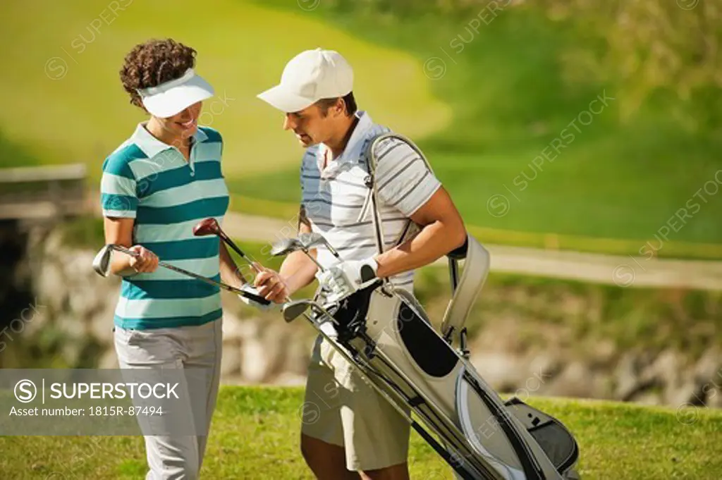 Italy, Kastelruth, Golfers choosing golf club on golf course