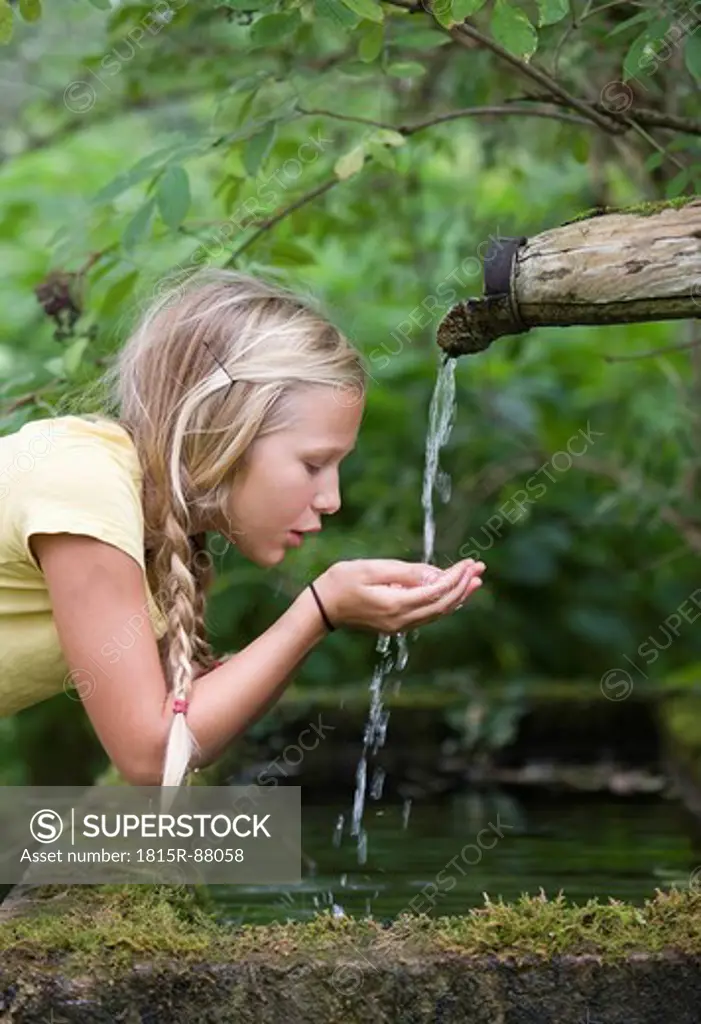 Austria, Mondsee, Girl 12_13 Years drinking water from water spout