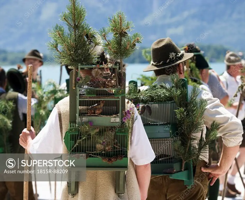 Austria, Salzkammergut, Bad Goisem, Men in traditional costume and birdcage