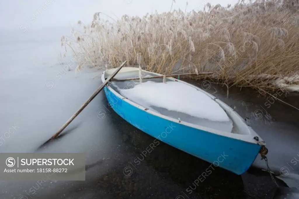 Austria, Salzkammergut, Rowing boat on frozen Irrsee lake