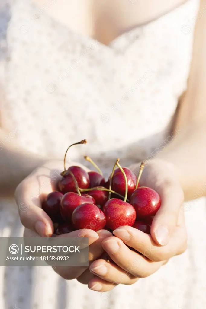 Woman holding cherries, close-up