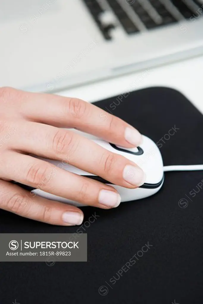 Germany, Bavaria, Diessen am Ammersee, Close up of woman´s hand on mouse with mousepad