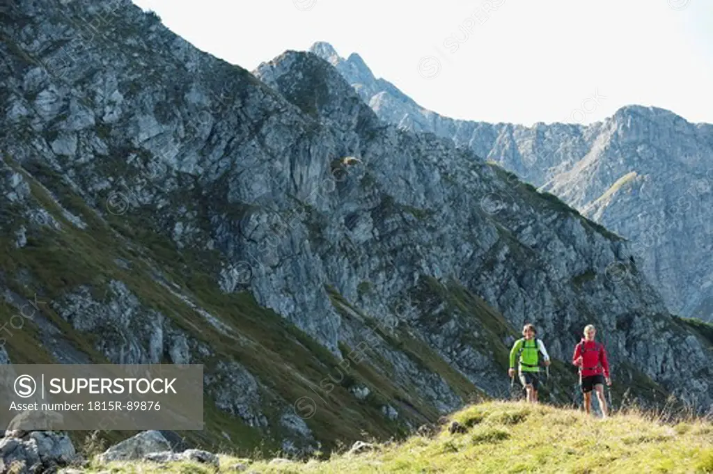 Austria, Kleinwalsertal, Man and woman hiking on mountain trail