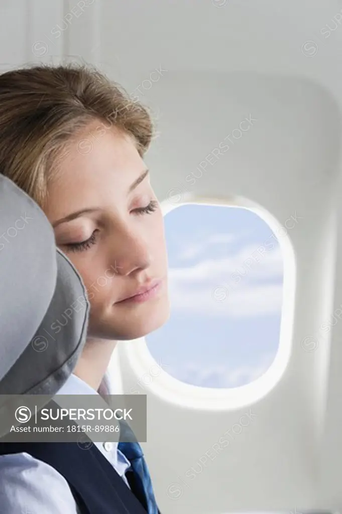 Germany, Bavaria, Munich, Close up of young stewardess sleeping in business class airplane cabin