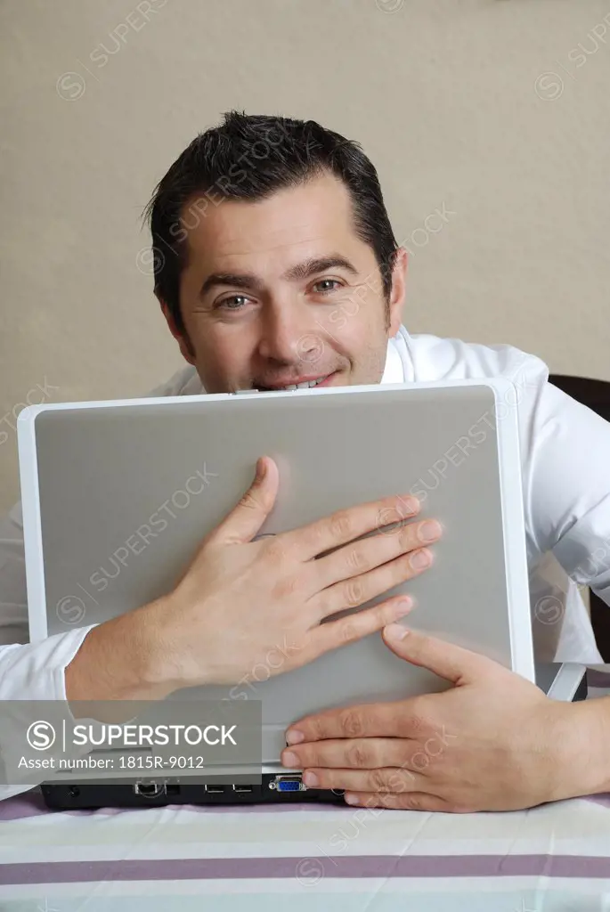 Young man with laptop, portrait