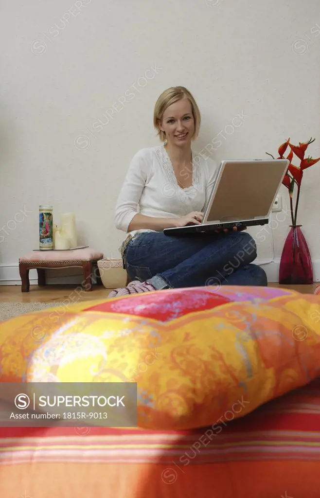 Blonde woman using laptop, portrait