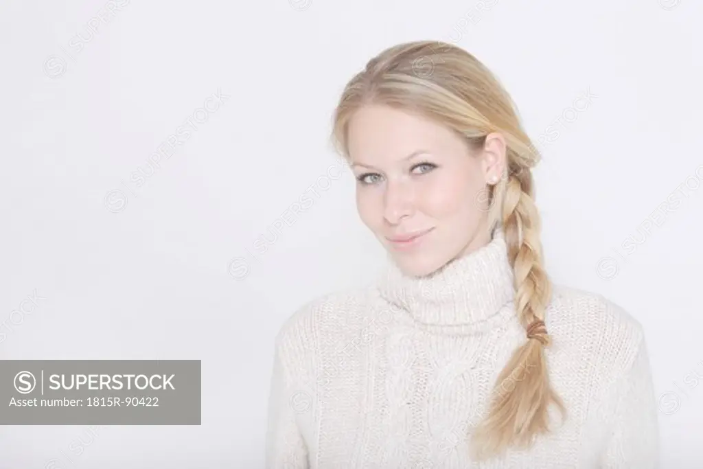 Young woman wearing turtleneck jumper and braided hairstyle against white background, portrait, smiling