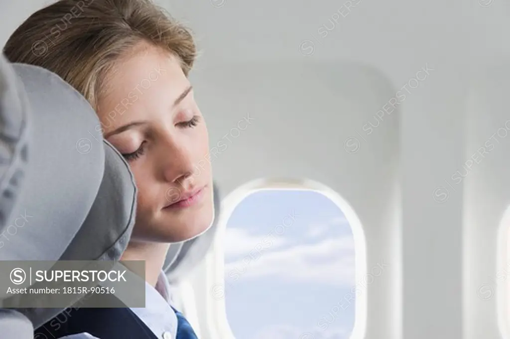 Germany, Bavaria, Munich, Close up of young stewardess sleeping in business class airplane cabin