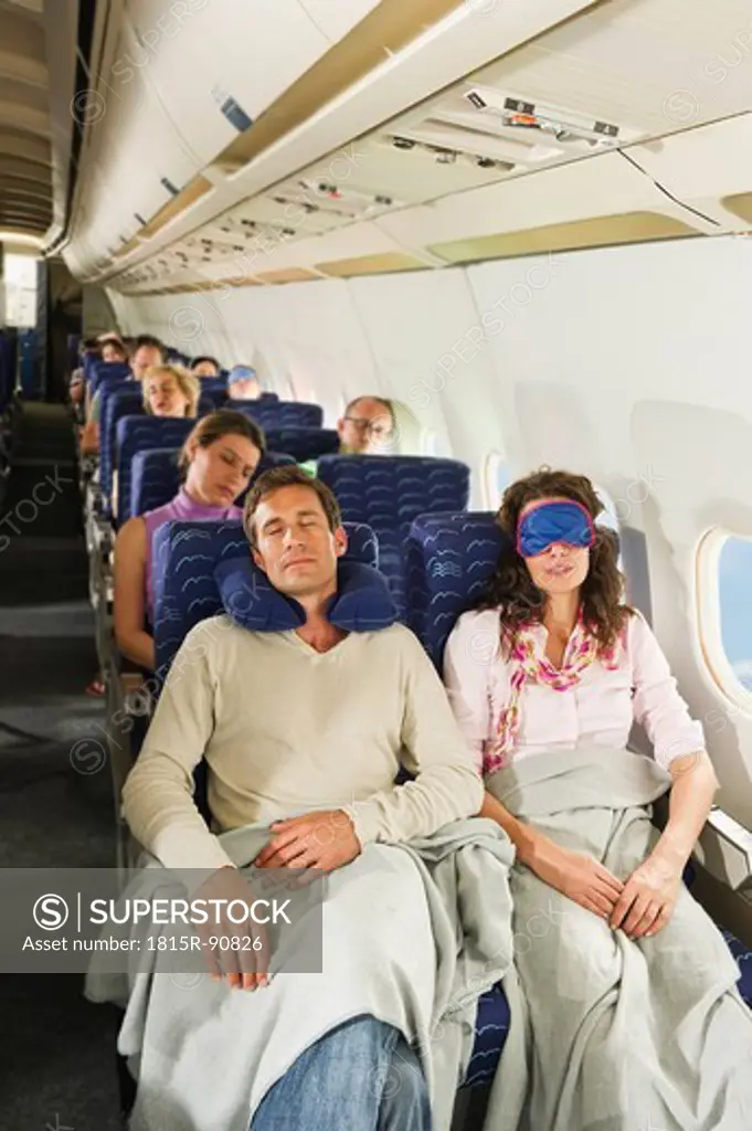 Germany, Munich, Bavaria, Passengers sleeping in economy class airliner