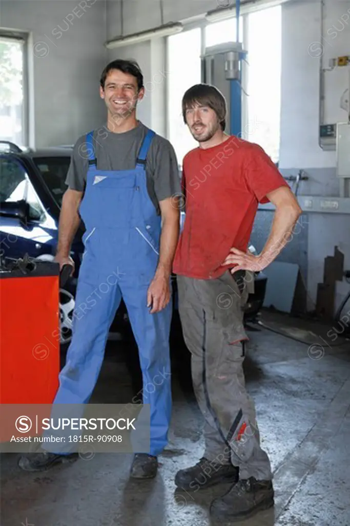 Germany, Ebenhausen, Mechatronic Technicians standing in repair garage, portrait