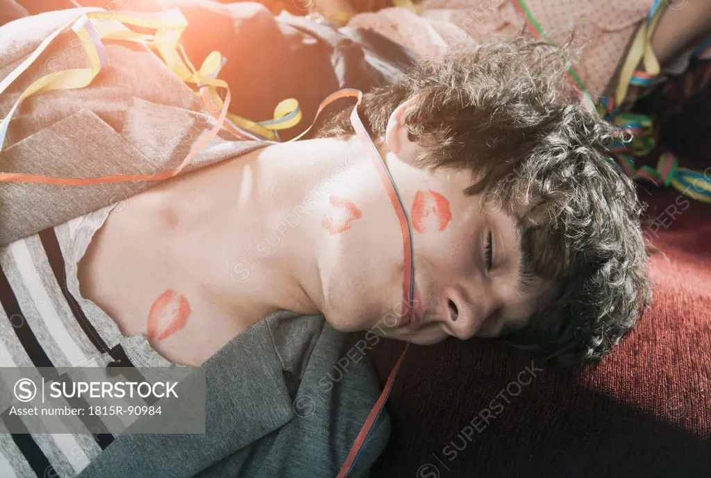 Germany, Berlin, Close up of young man with lipstick kiss sleeping after party