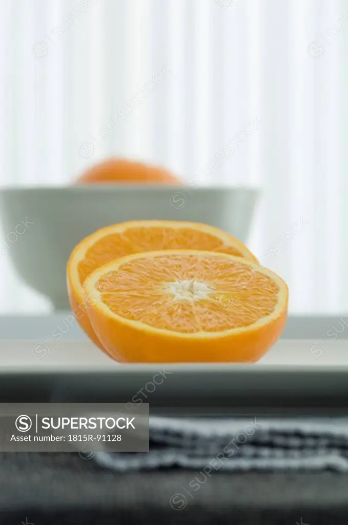 Half cut oranges on plate, close up