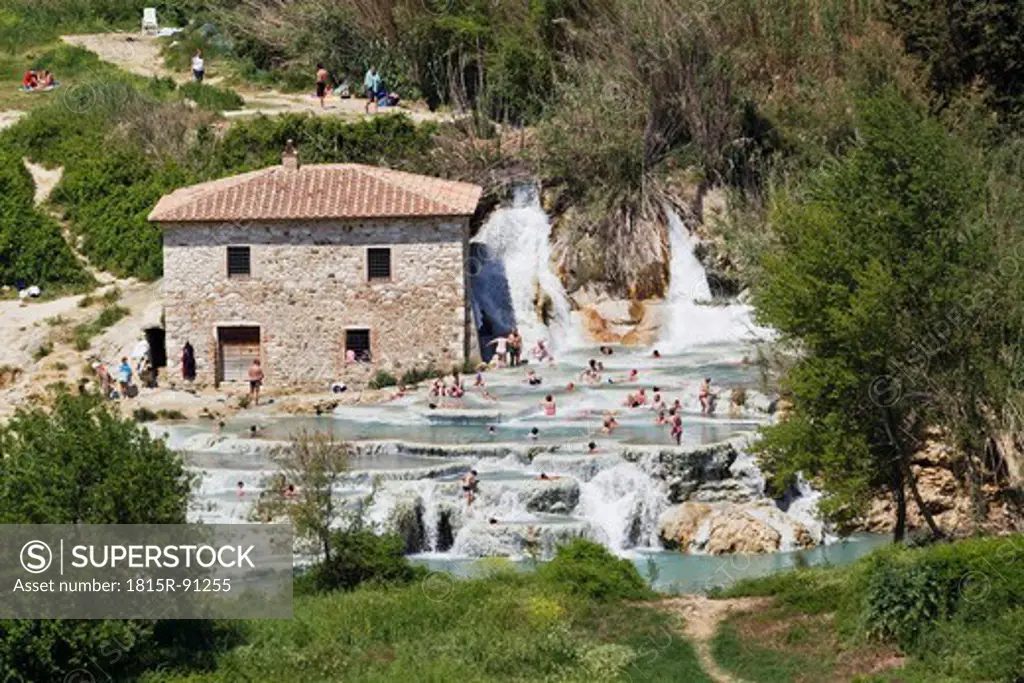 Italy, Tuscany, Province of Grosseto, Saturnia, View of people at thermal waterfalls and travertine pool