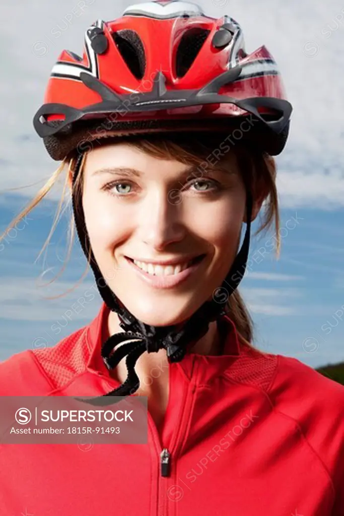 Germany, Bavaria, Young woman wearing cycling helmet, close up, portrait