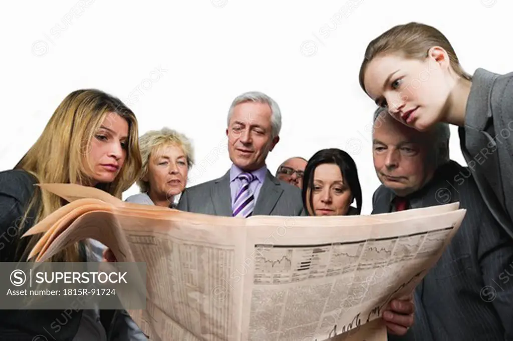 Business people reading newspaper against white background