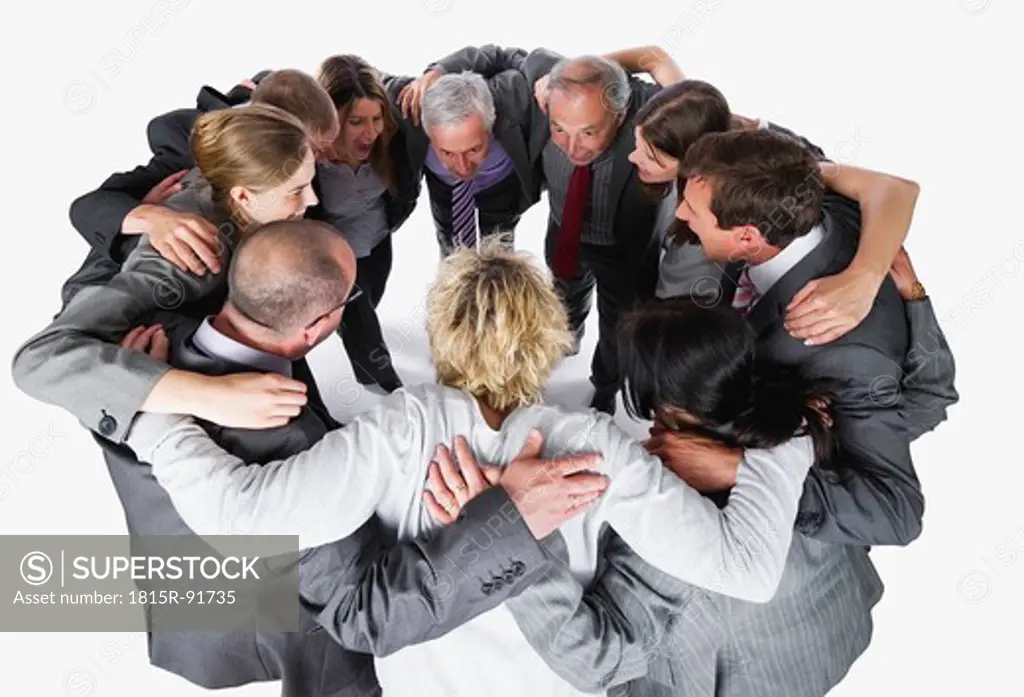 Business people forming huddle against white background