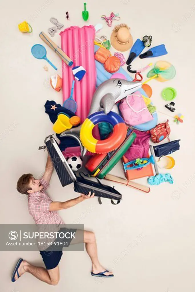 Germany, Artificial scene with man opening baggage full of beach toys